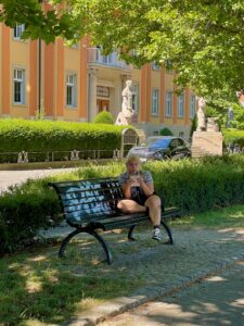 Junge Frau auf einer bemalten Bank.