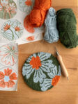 Ein Untersetzer aus stilisierten Margeriten in Punchneedle-Technik gearbeitet.